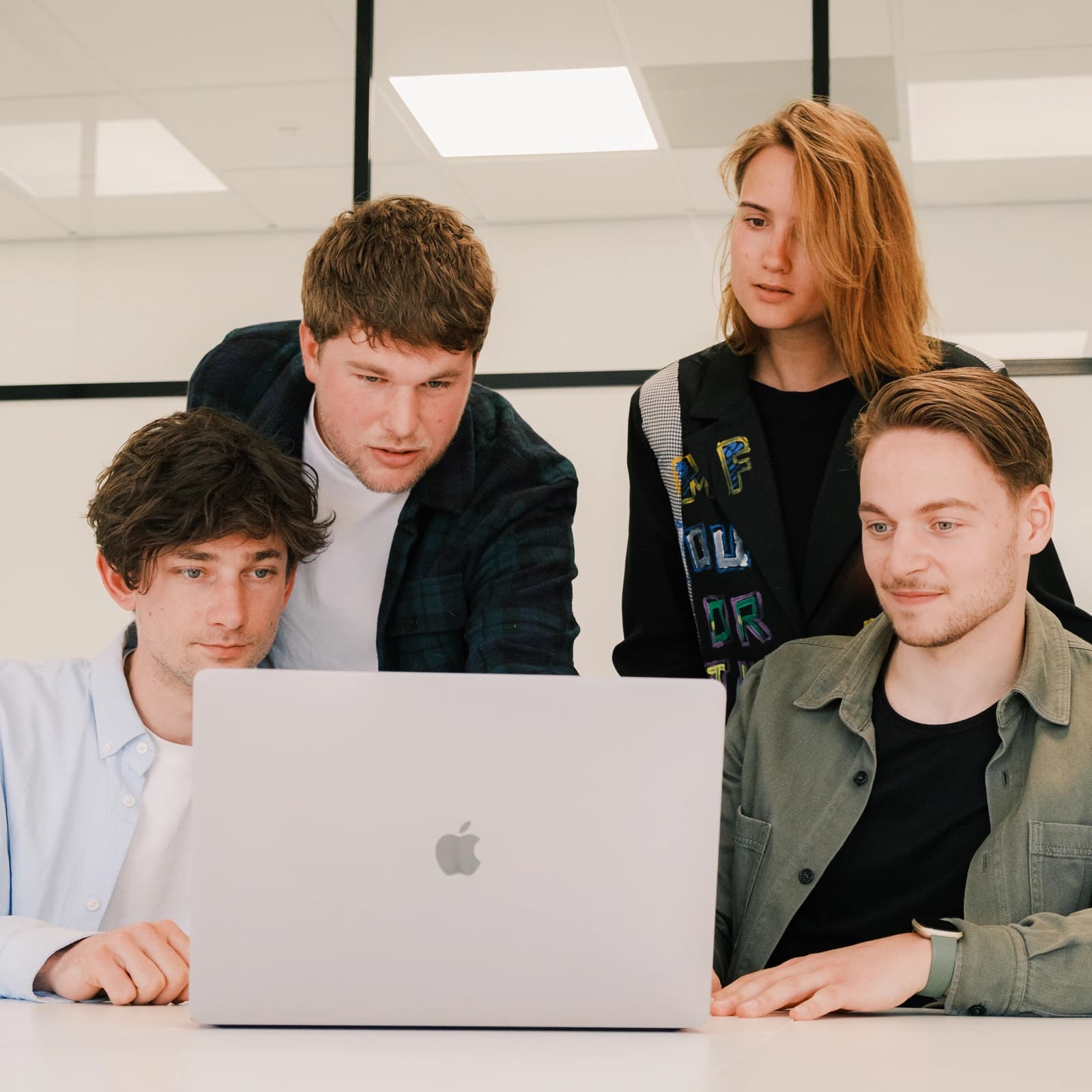 Het team van Digital KISS vergadert rond de laptop van Sam